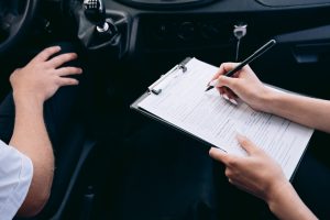 Personne écrivant sur un formulaire dans une voiture