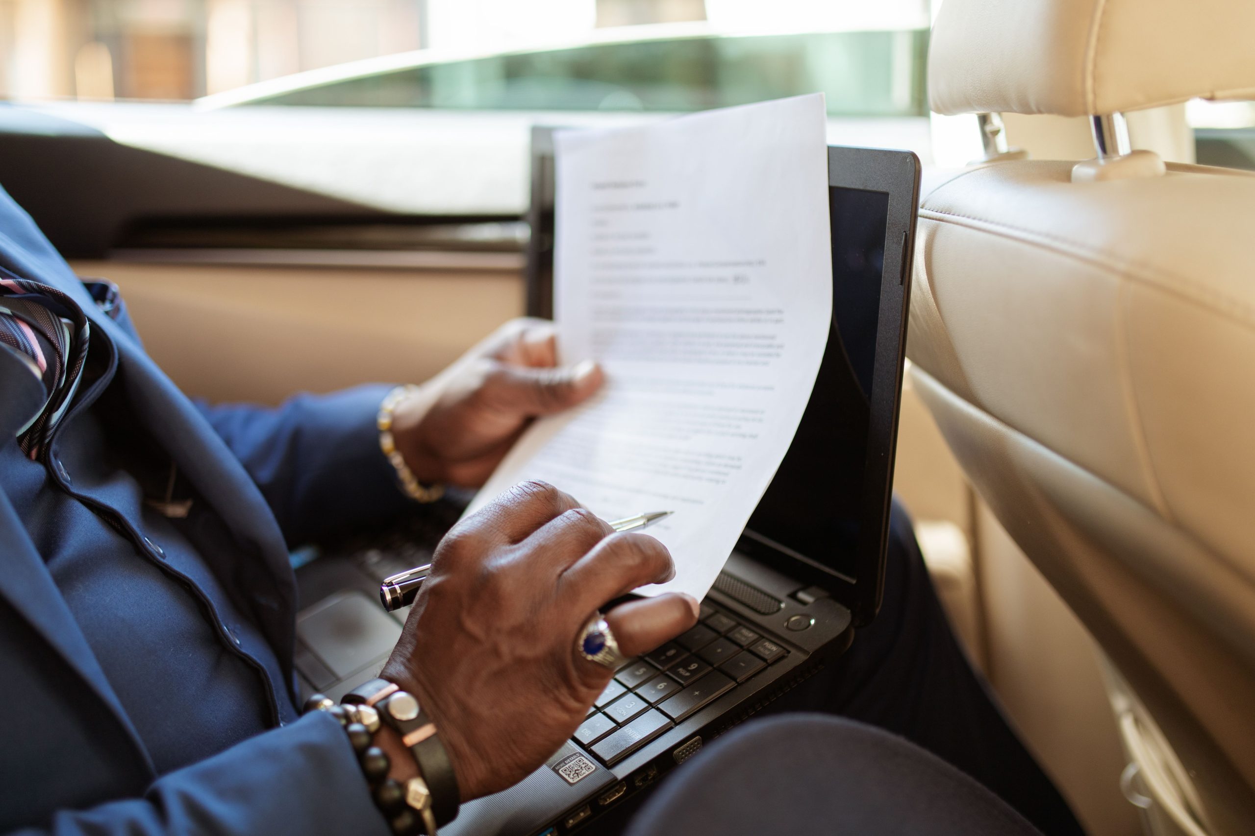 Homme consultant des papiers sur ordinateur en voiture