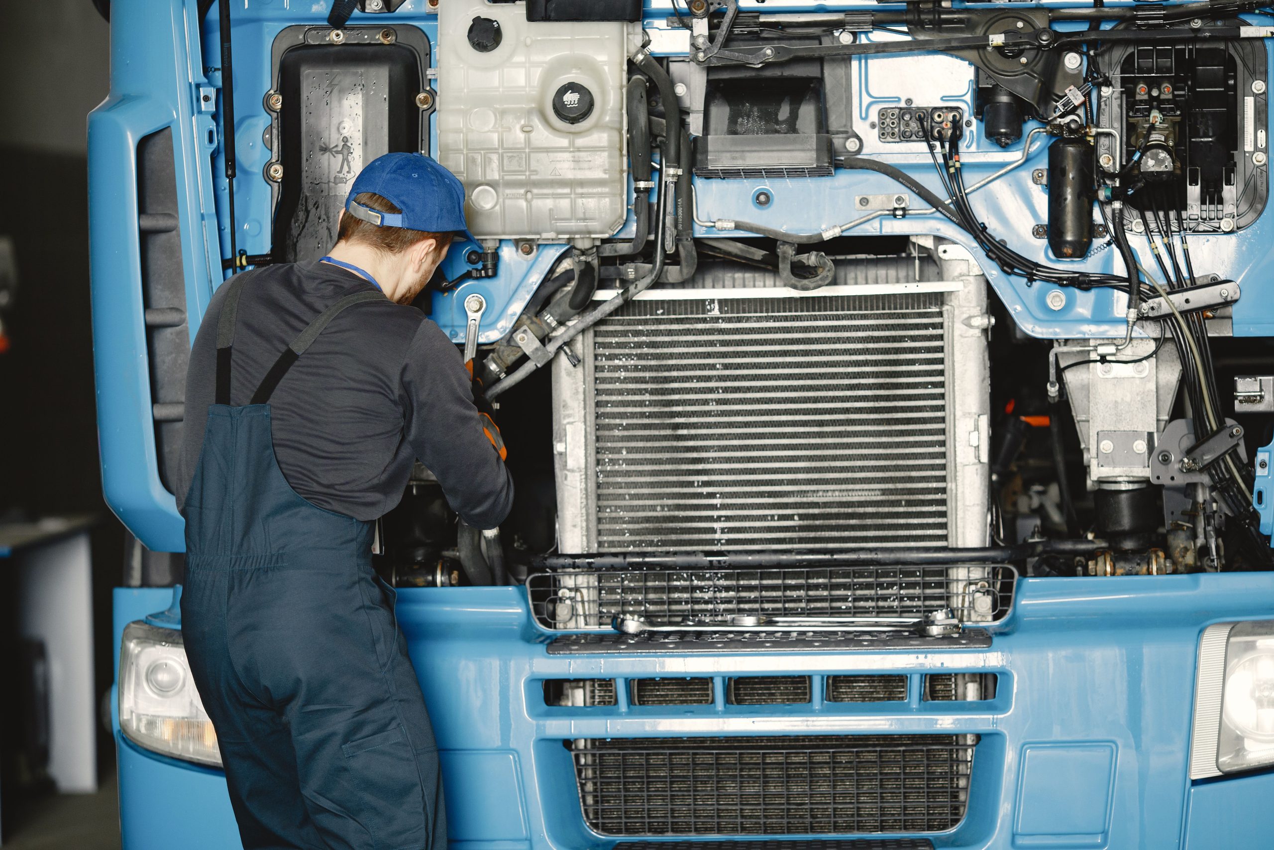 Mécanicien en uniforme travaillant moteur utilitaire