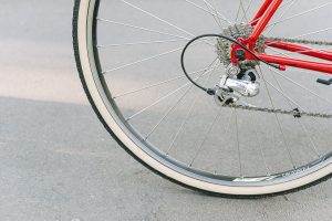 Roue vélo rouge et mécanisme pignon sur bitume