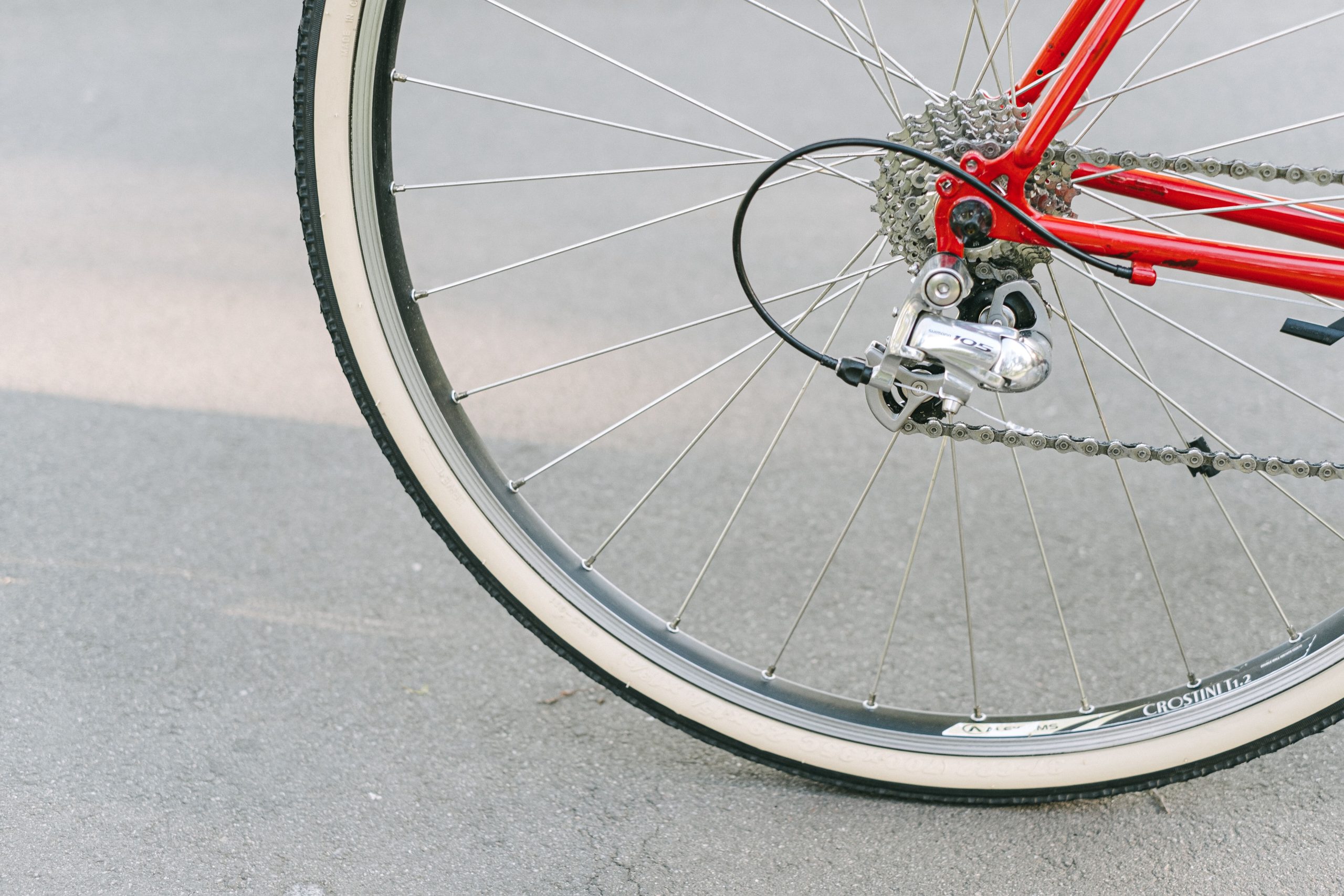 Roue vélo rouge et mécanisme pignon sur bitume