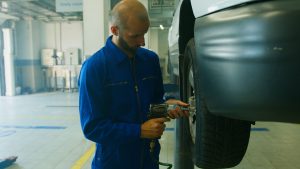 Mécanicien en uniforme réparant une voiture
