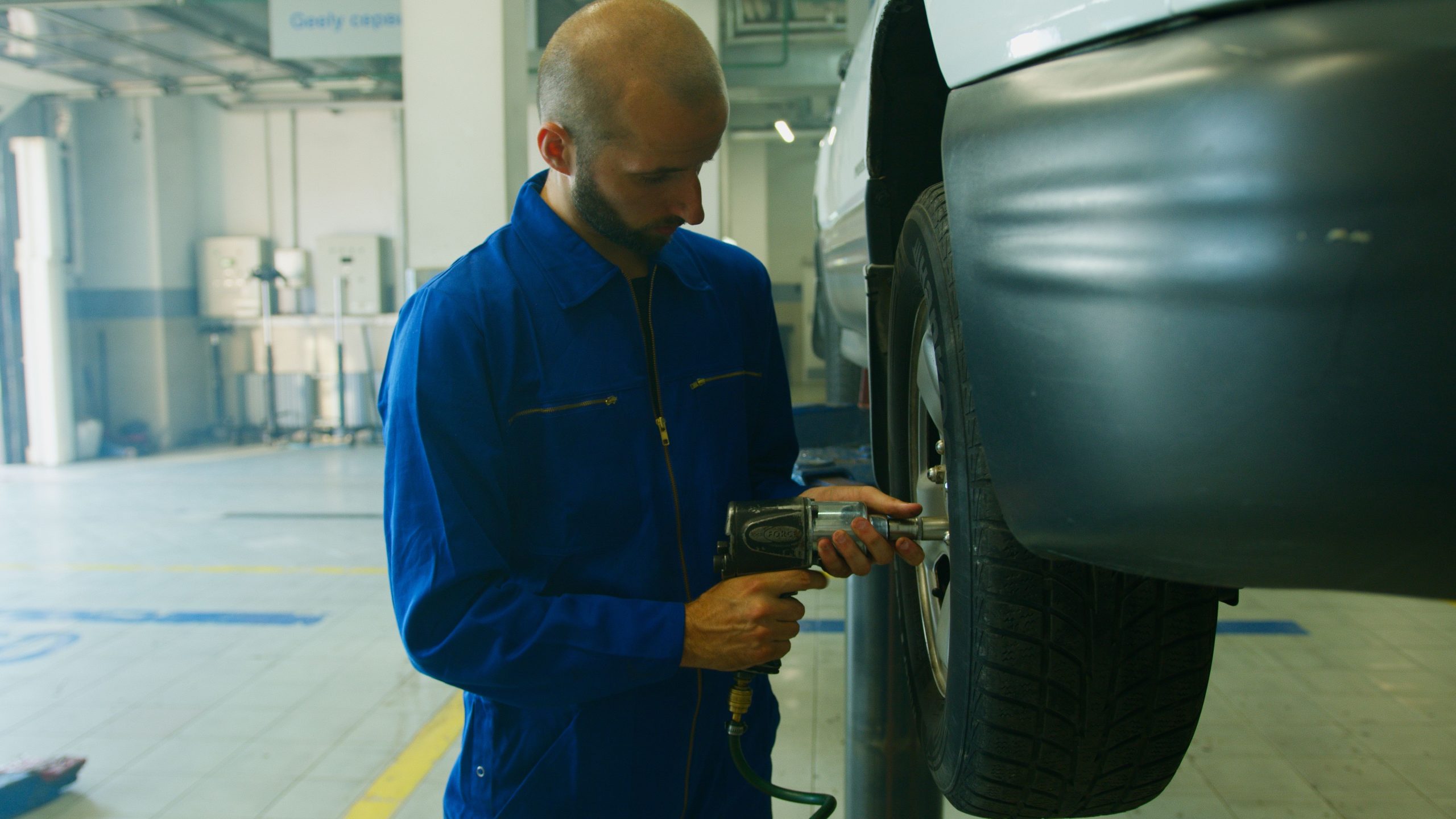Mécanicien en uniforme réparant une voiture