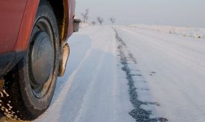 Pneu automobile sur route enneigée en hiver