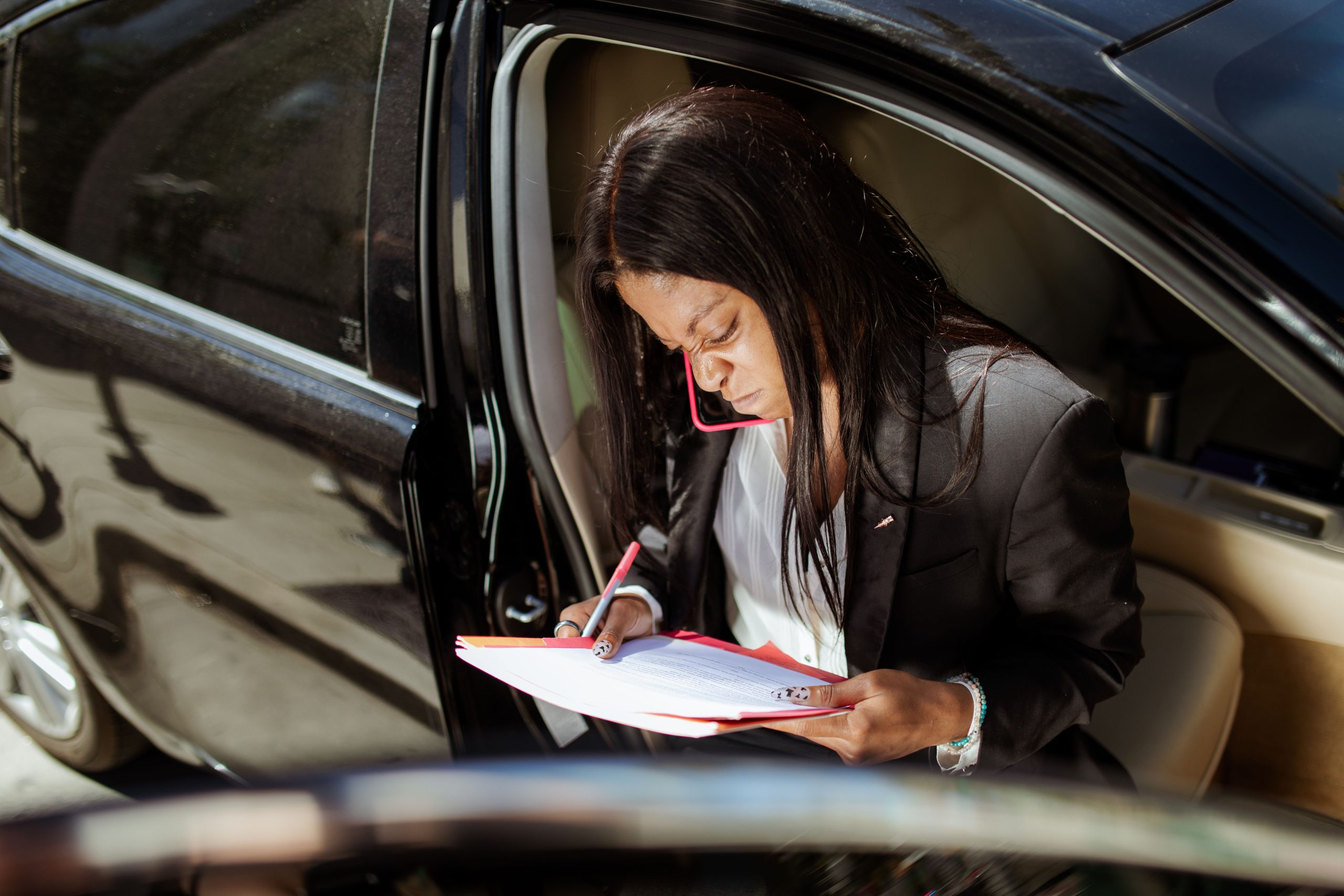 Femme analysant des documents administratifs en voiture