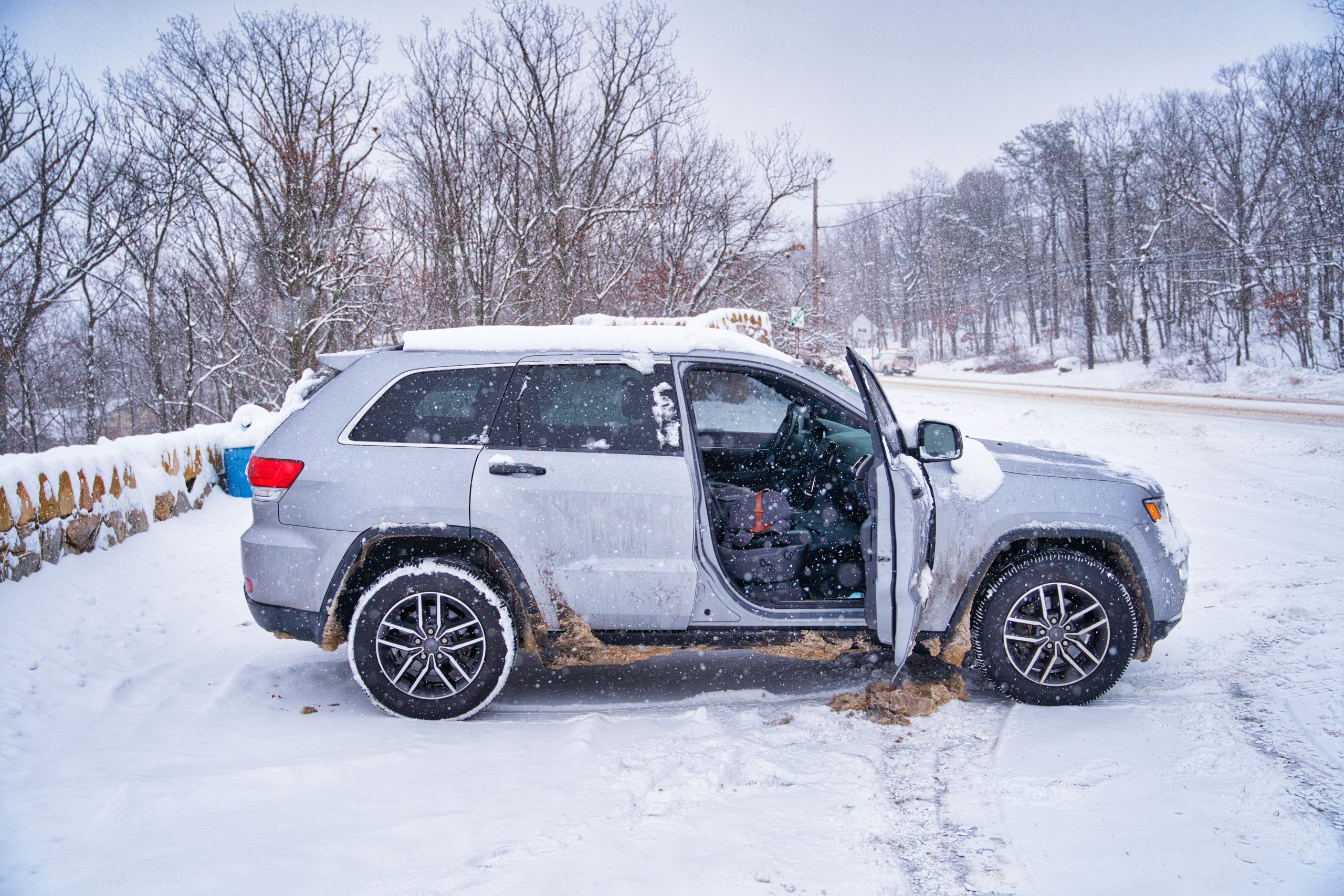 SUV gris route enneigee arbres hiver