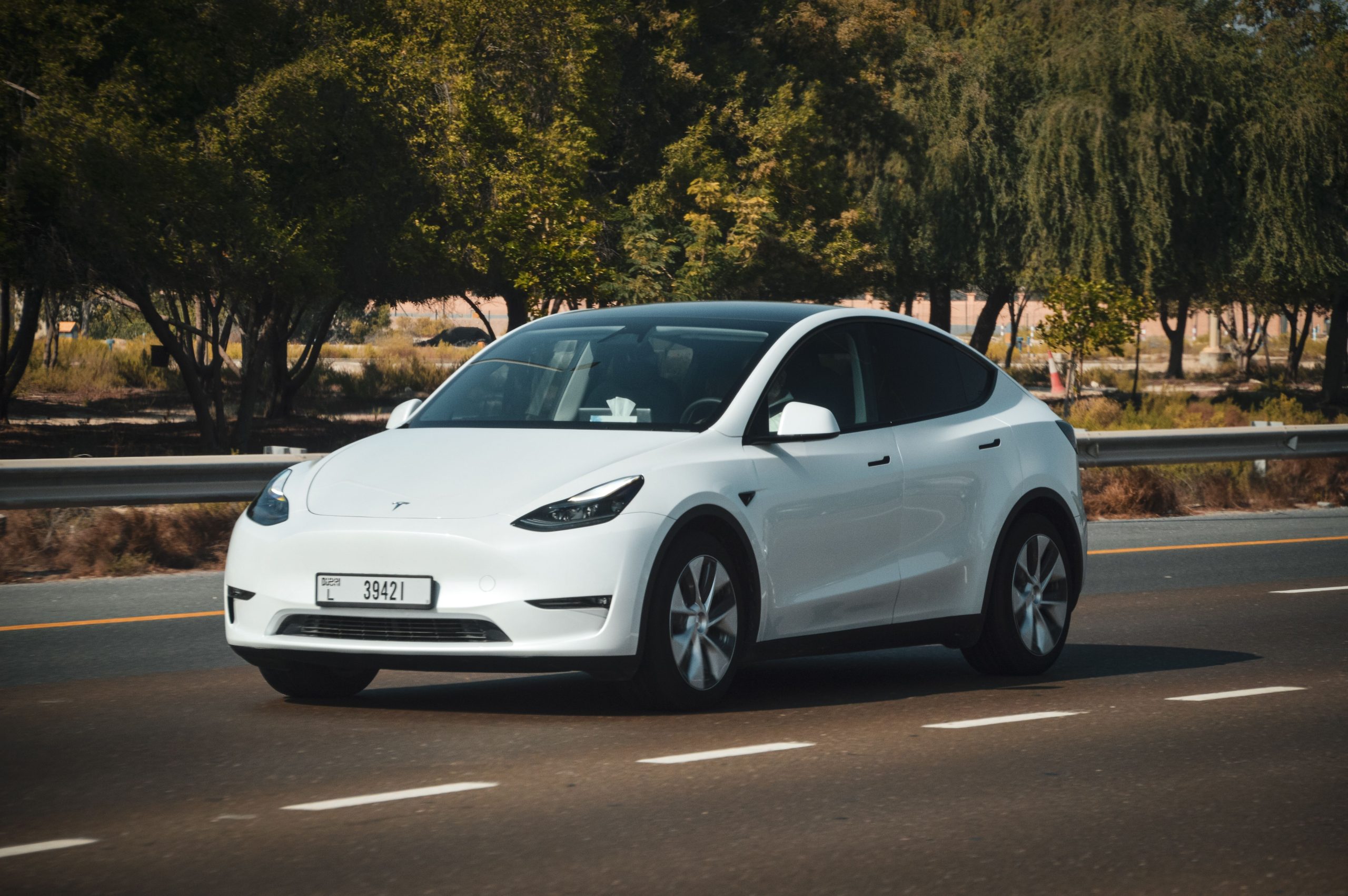 Voiture électrique blanche roulant sur autoroute ensoleillée