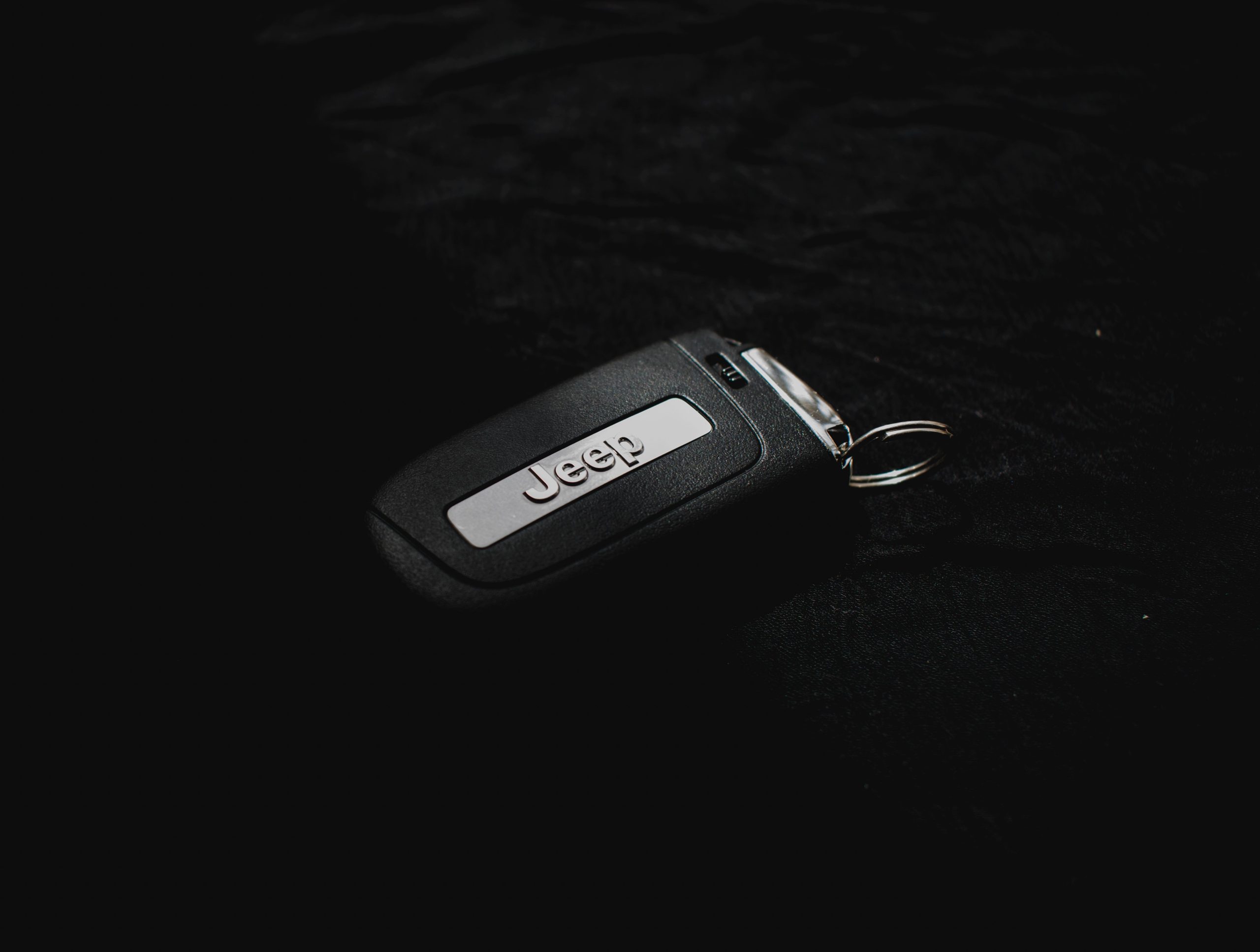 Clé Jeep minimaliste sur surface sombre