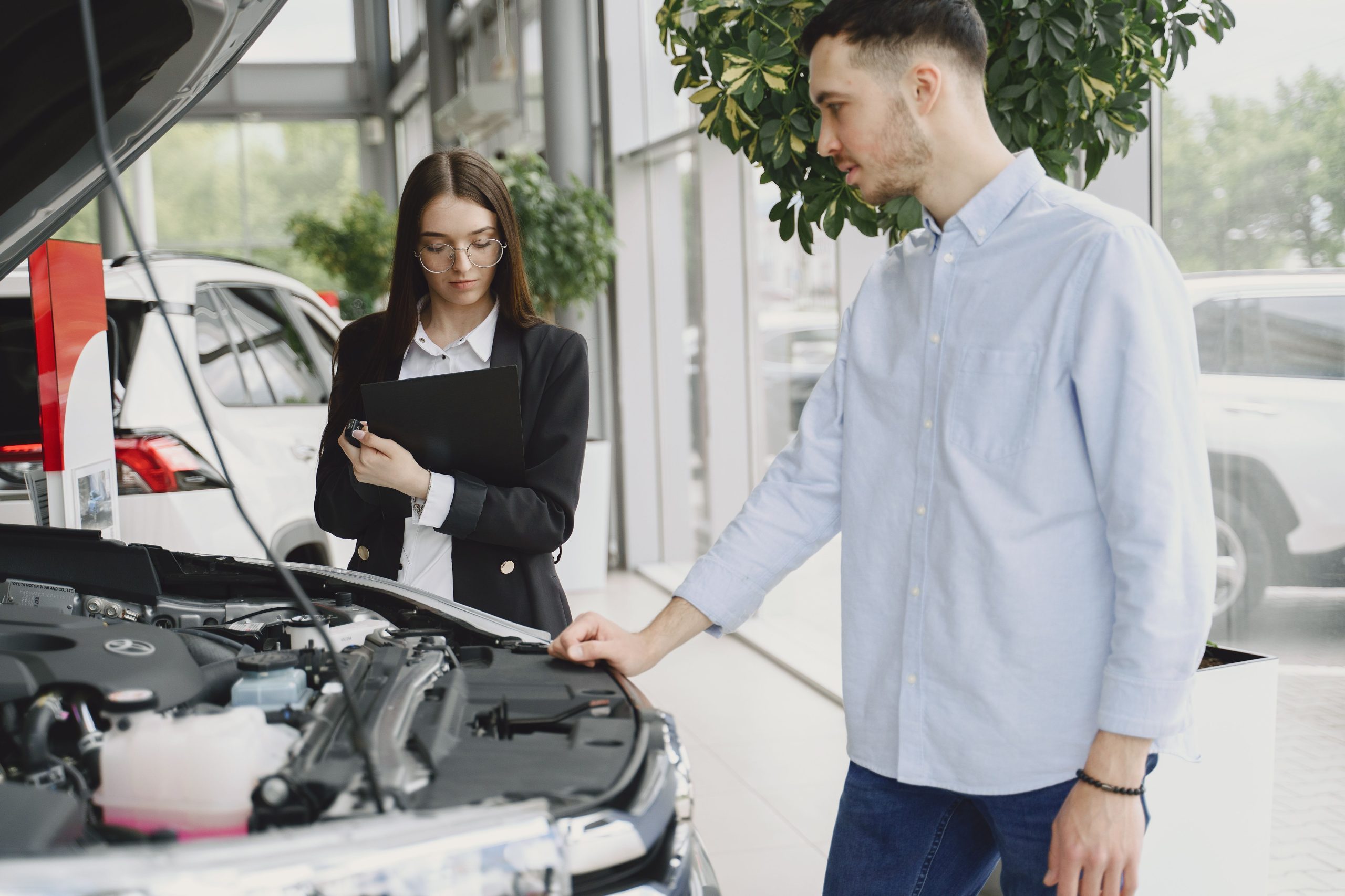 Couple examinant moteur voiture en concession