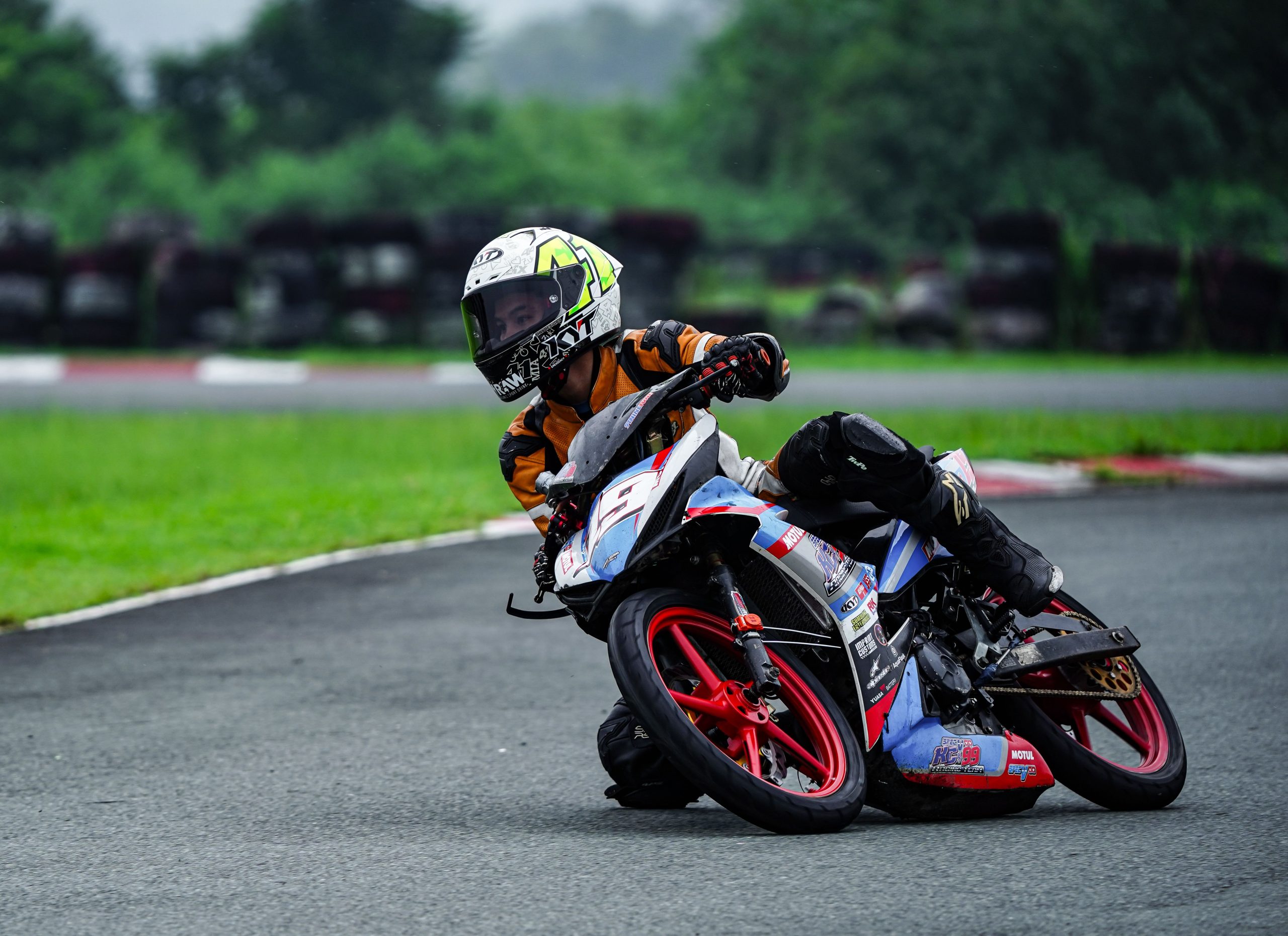 Jeune pilote en virage sur piste motocycliste